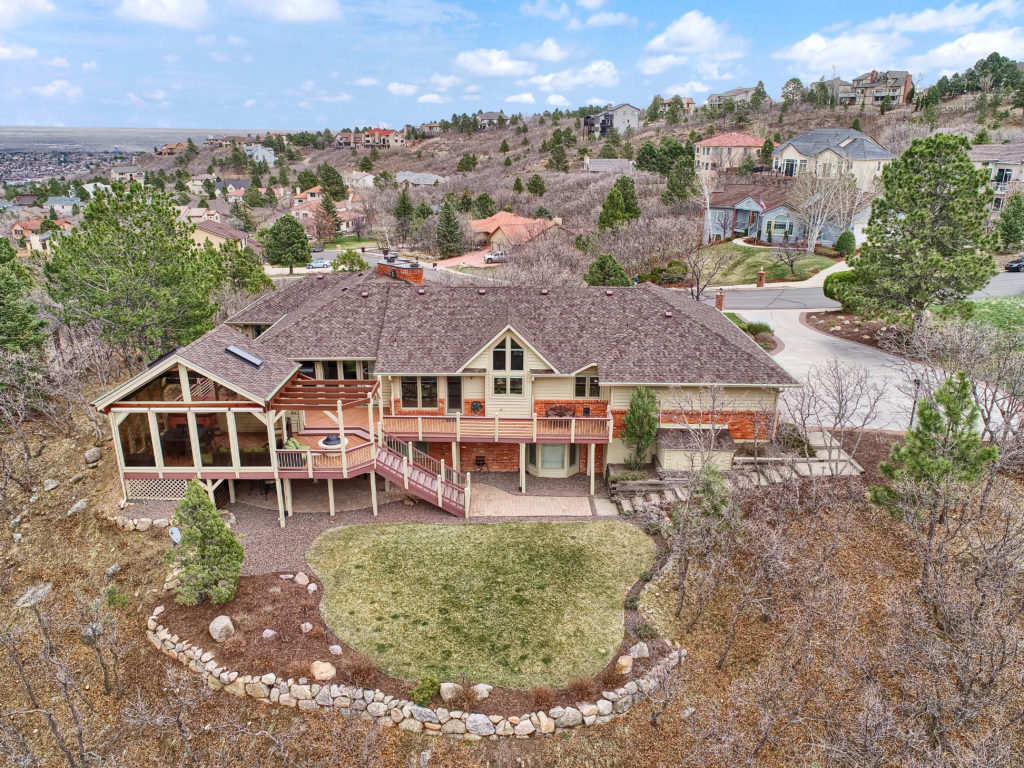 Elegant Broadmoor Hills home for sale with large windows and custom deck to enjoy the incredible mountain views.